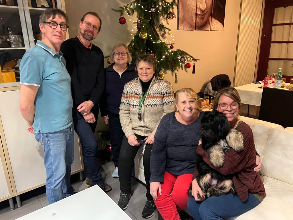 Deidre with friends gathered by a Christmas tree