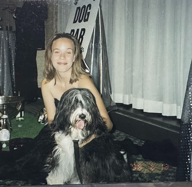 Deidre at a party next to a dog bar sign